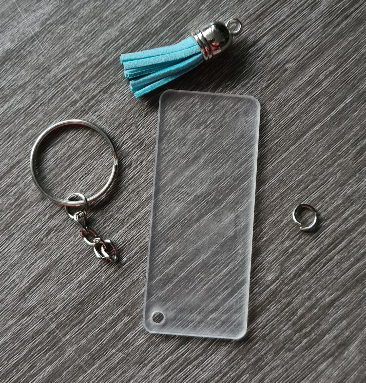 Set of 5 rectangular acrylic key rings with tassels and chain.